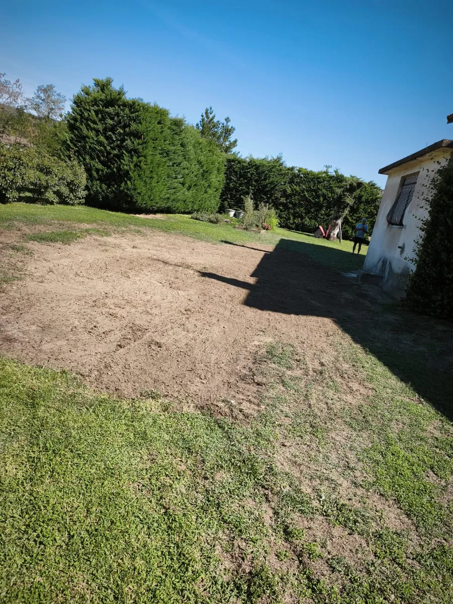 Terrain rebouché et repris au niveau, prêt à être réengazonné