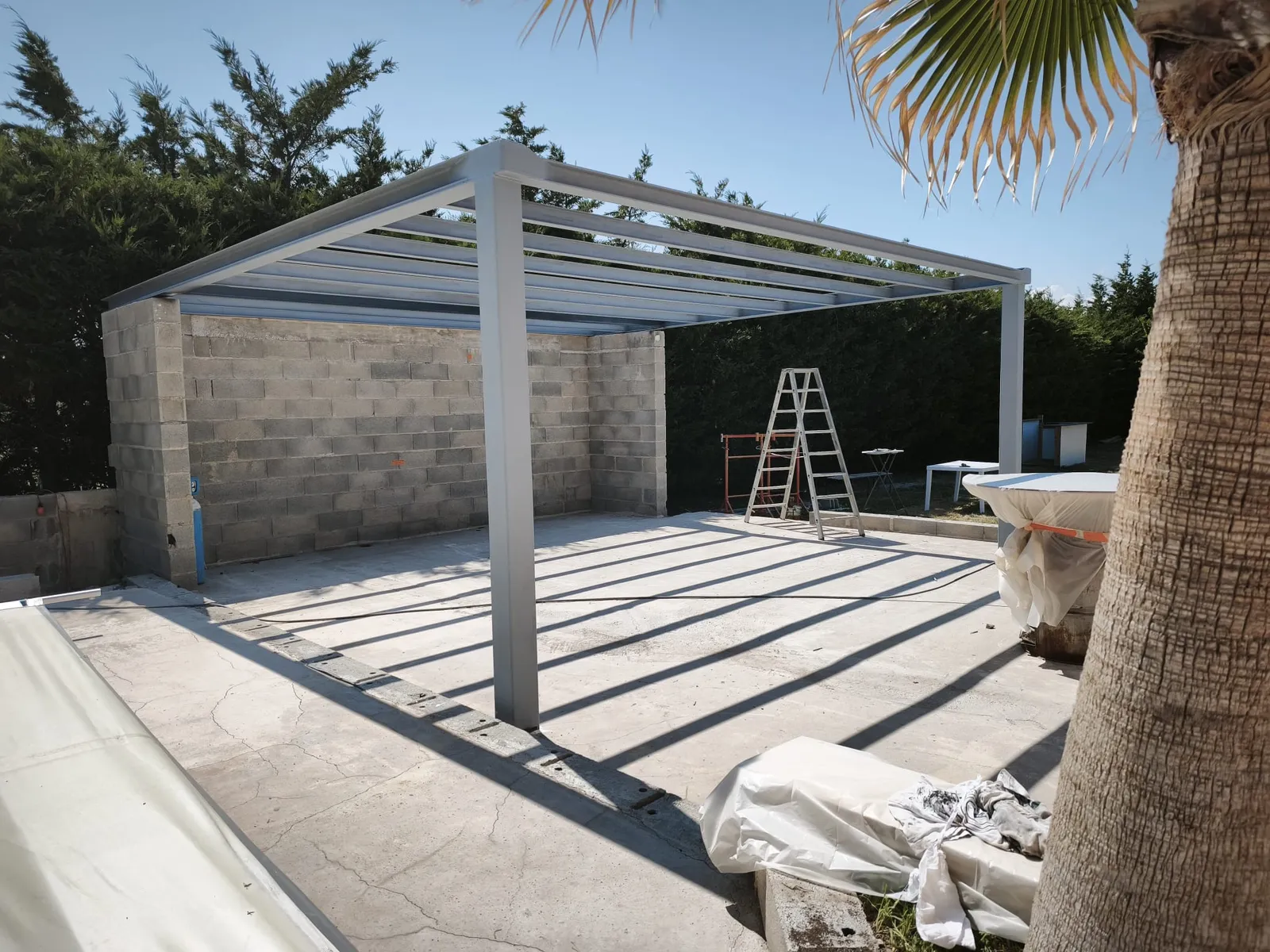 Pool house en parpaing avec dalle béton et pergola aluminium, chantier à Chabeuil